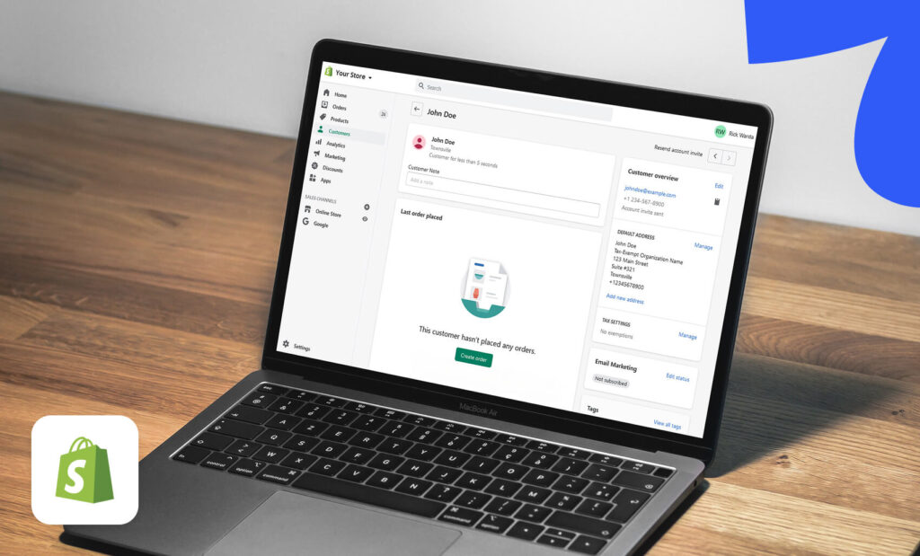 A laptop displaying the Shopify admin dashboard showing a customer profile page